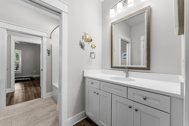 bathroom with hardwood / wood-style flooring, vanity, and  shower combination