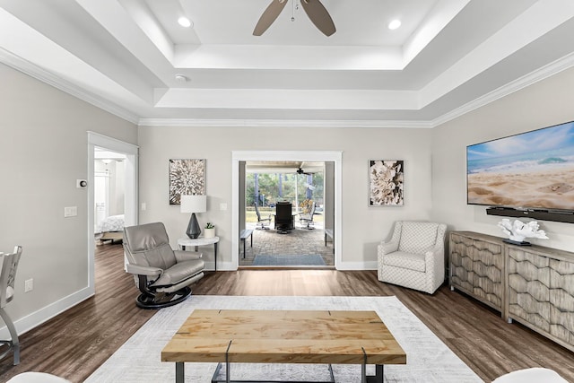 living area with dark hardwood / wood-style flooring, crown molding, a raised ceiling, and ceiling fan