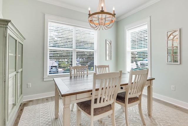 dining area featuring crown molding, plenty of natural light, a notable chandelier, and light wood-type flooring