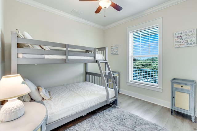 bedroom with crown molding, ceiling fan, and hardwood / wood-style flooring