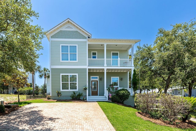 view of front of property with a balcony, a porch, and a front lawn