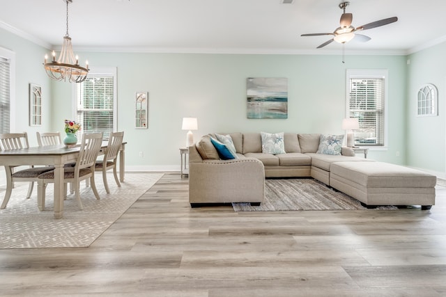 living room with crown molding, light hardwood / wood-style flooring, and ceiling fan with notable chandelier