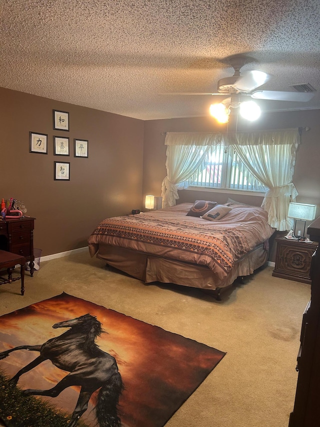 bedroom with ceiling fan, carpet, and a textured ceiling