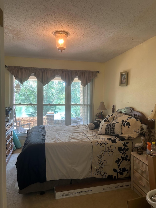 bedroom featuring a textured ceiling and carpet