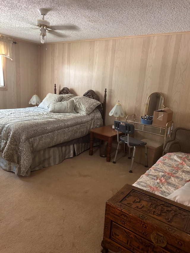 carpeted bedroom with ceiling fan, a textured ceiling, and wood walls