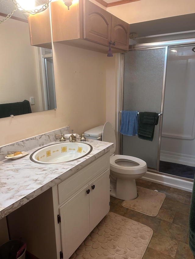 bathroom with vanity, a shower with shower door, and toilet