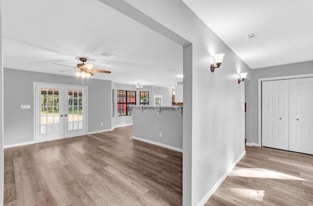 unfurnished living room featuring light hardwood / wood-style flooring, french doors, and ceiling fan