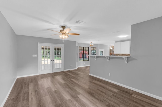 unfurnished living room with french doors, ceiling fan, and light wood-type flooring