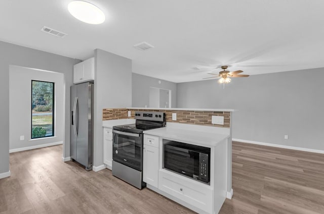 kitchen featuring stainless steel appliances, white cabinets, ceiling fan, and light hardwood / wood-style flooring