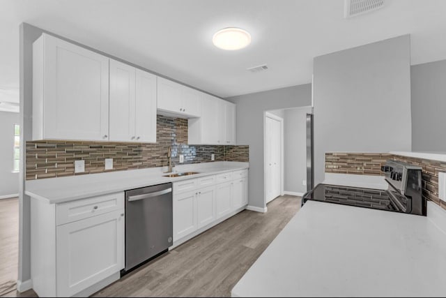 kitchen with white cabinetry, appliances with stainless steel finishes, light hardwood / wood-style floors, and sink