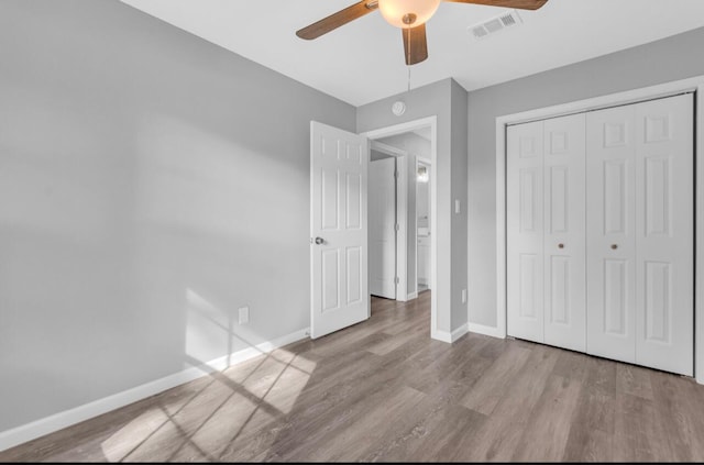 unfurnished bedroom with ceiling fan, light hardwood / wood-style floors, and a closet