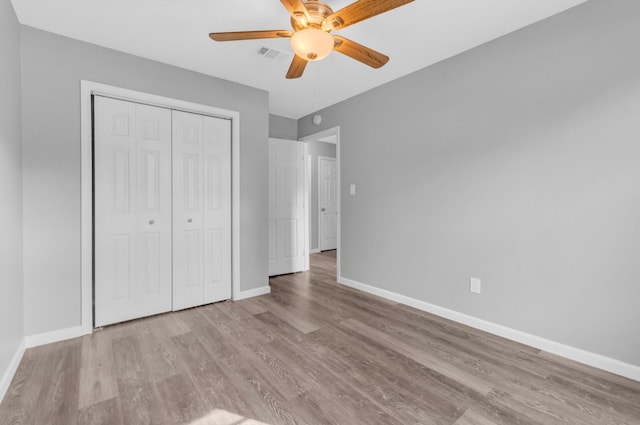 unfurnished bedroom featuring ceiling fan, light wood-type flooring, and a closet