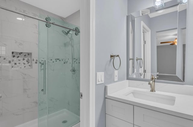 bathroom with vanity, a shower with shower door, and ceiling fan