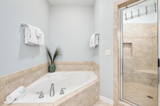 bathroom with a stall shower, tile patterned floors, and a bath