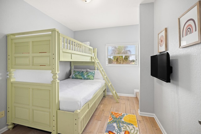 bedroom with light wood finished floors and baseboards