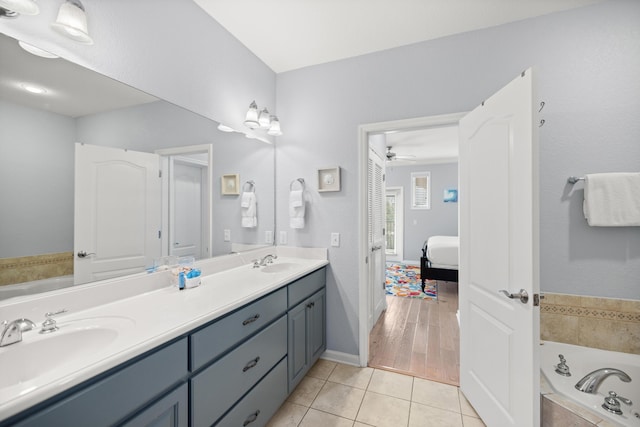 ensuite bathroom featuring a bath, tile patterned flooring, a sink, and ensuite bathroom