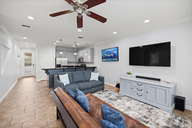 living area featuring light tile patterned floors, ornamental molding, visible vents, and recessed lighting