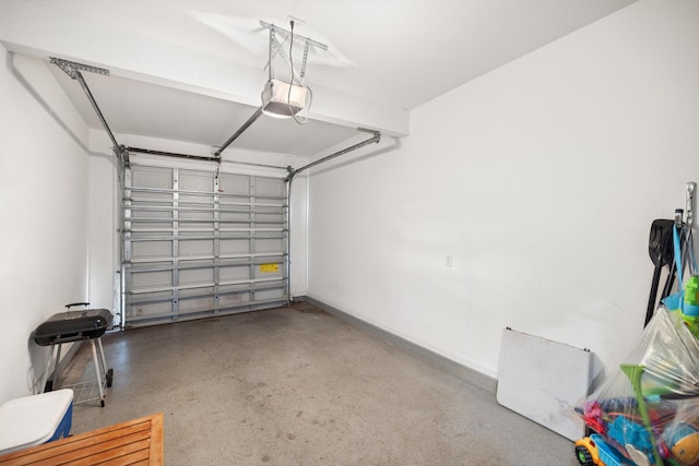 garage featuring a garage door opener and baseboards