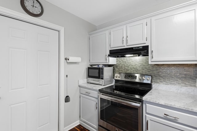 kitchen featuring white cabinetry, backsplash, stainless steel appliances, and light stone countertops