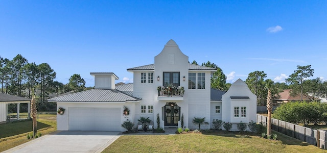 view of front facade with a garage, a balcony, and a front lawn