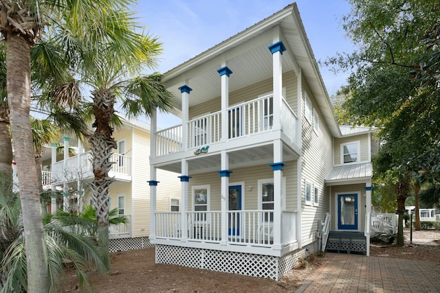 back of house featuring a balcony and covered porch