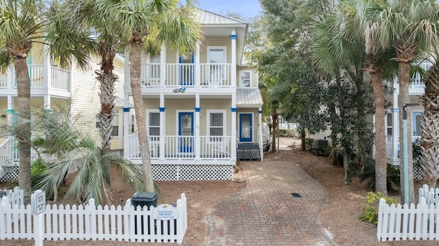 coastal inspired home with a balcony, central AC, and covered porch