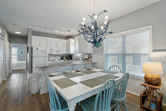 dining room with an inviting chandelier, dark hardwood / wood-style floors, and sink