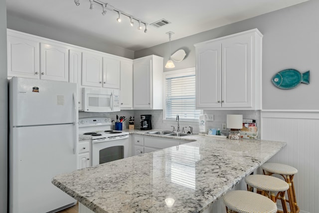 kitchen with white cabinetry, white appliances, decorative light fixtures, and sink