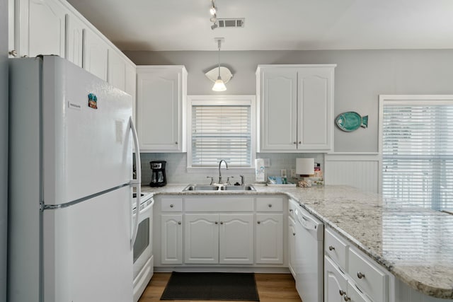 kitchen with white cabinetry, sink, pendant lighting, and white appliances