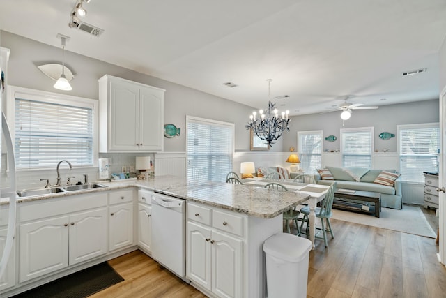 kitchen featuring white cabinetry, white dishwasher, kitchen peninsula, and sink