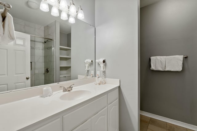 bathroom featuring an enclosed shower, vanity, and tile patterned flooring