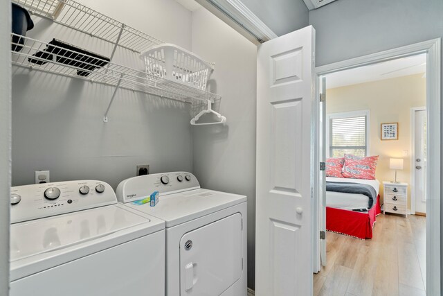 laundry area with washing machine and dryer and light hardwood / wood-style floors