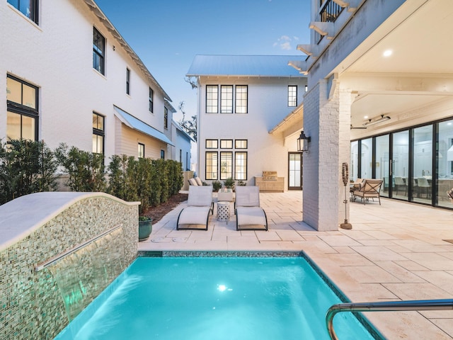 view of swimming pool featuring pool water feature and a patio