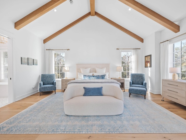 bedroom with beam ceiling, light hardwood / wood-style flooring, and high vaulted ceiling