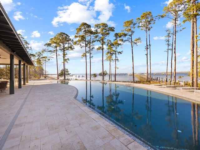 view of pool featuring a patio area and a water view