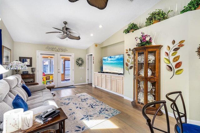 living room with vaulted ceiling, hardwood / wood-style floors, ceiling fan, and french doors