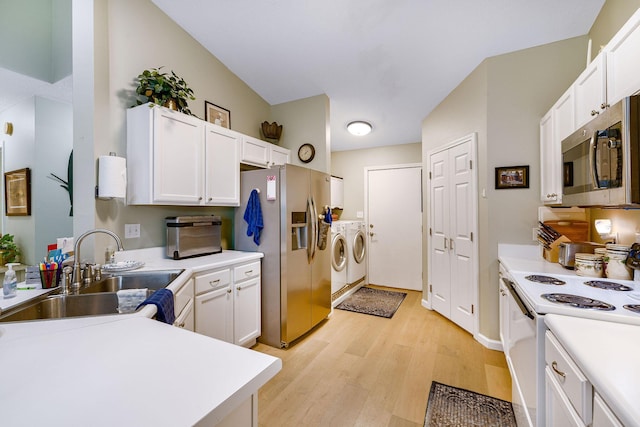 kitchen featuring appliances with stainless steel finishes, washer and clothes dryer, sink, and white cabinets