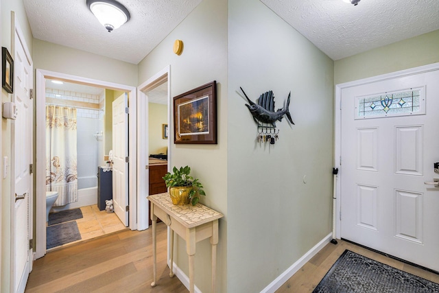 entrance foyer with light hardwood / wood-style flooring and a textured ceiling