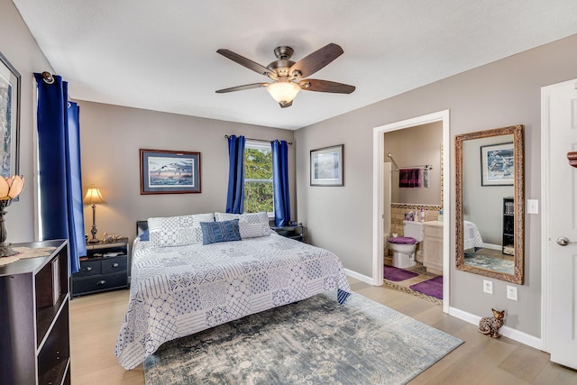 bedroom featuring ensuite bath, light hardwood / wood-style flooring, and ceiling fan