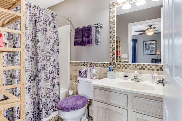 full bathroom with toilet, shower / tub combo, tile walls, vanity, and ceiling fan