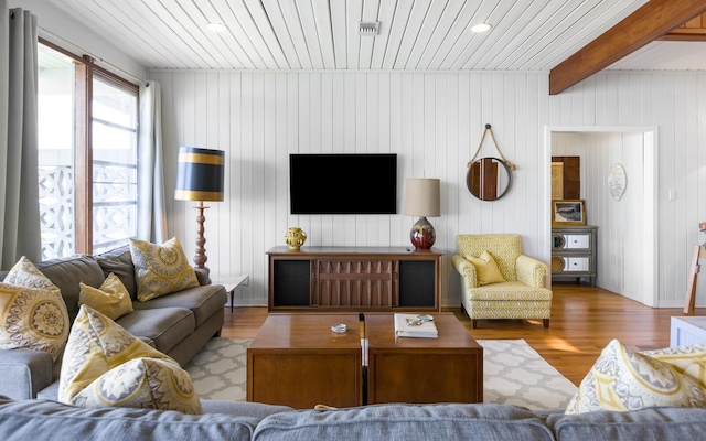 living room featuring beamed ceiling, wood ceiling, and light hardwood / wood-style flooring