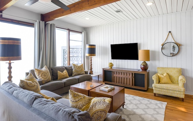 living room with beam ceiling, light hardwood / wood-style flooring, and ceiling fan