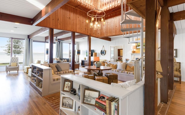 living room with beamed ceiling, a notable chandelier, and light hardwood / wood-style flooring