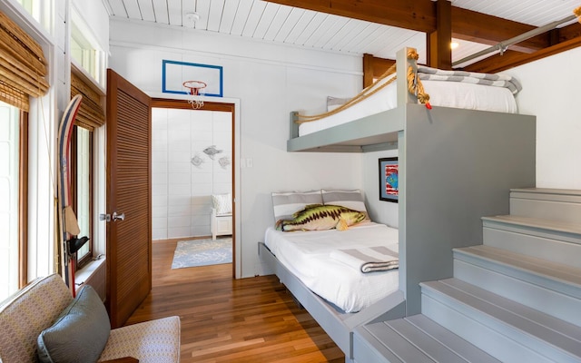 bedroom featuring hardwood / wood-style floors and beamed ceiling