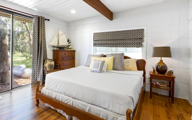 bedroom with beamed ceiling, wooden ceiling, hardwood / wood-style floors, and access to exterior