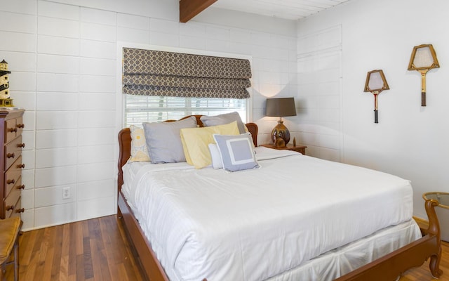 bedroom with dark wood-type flooring and beamed ceiling