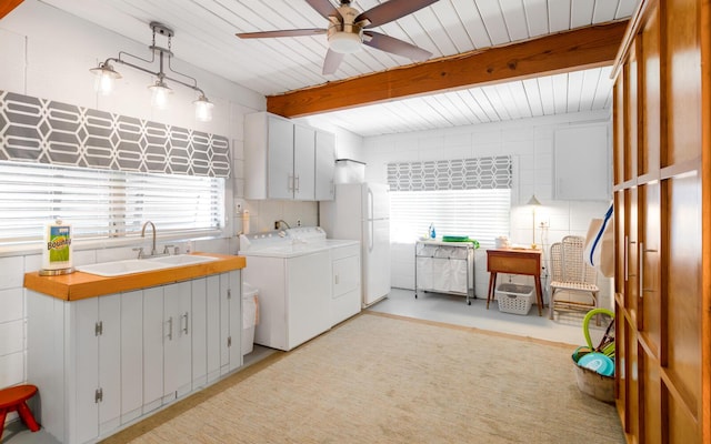 washroom with ceiling fan, cabinets, sink, and washing machine and dryer