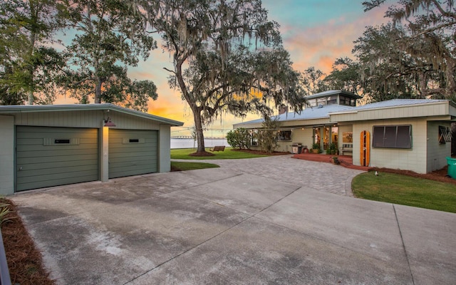 exterior space featuring a garage and a lawn