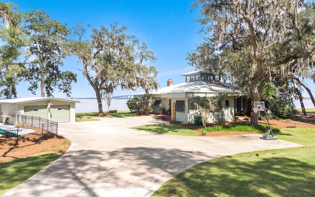 view of front of home featuring a garage, an outbuilding, and a front yard