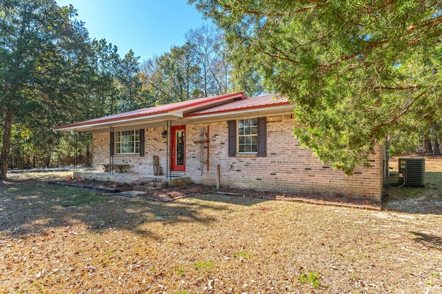 view of front of property with a front lawn and central air condition unit